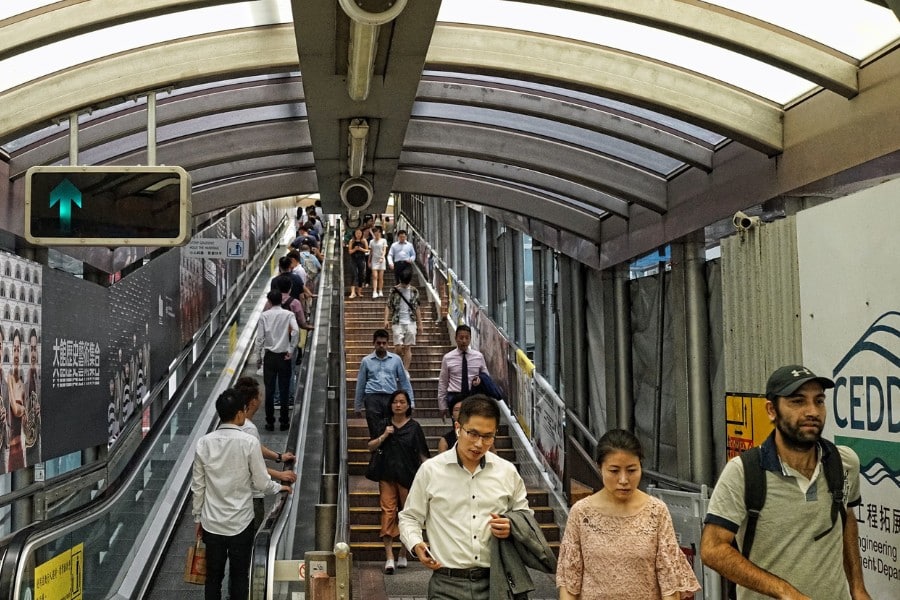 people riding the mid-level escalator in central