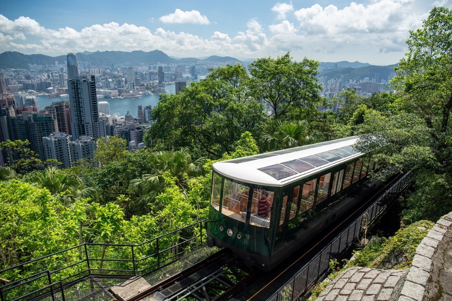 the peak tram going up to the peak with city views behind